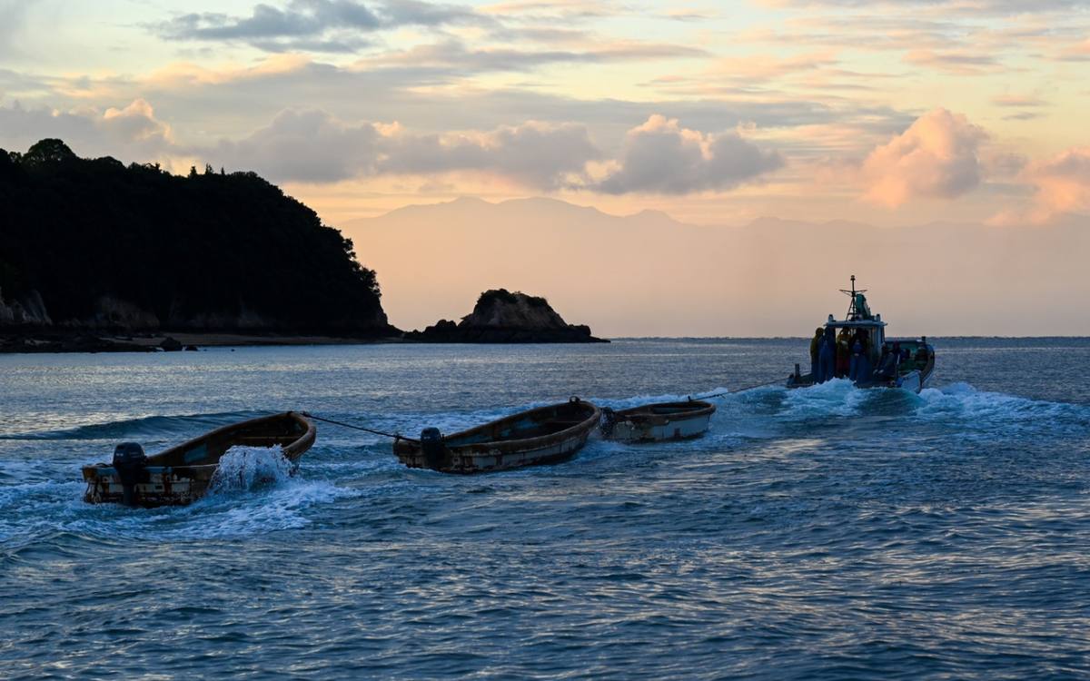夕暮れの海を戻る船